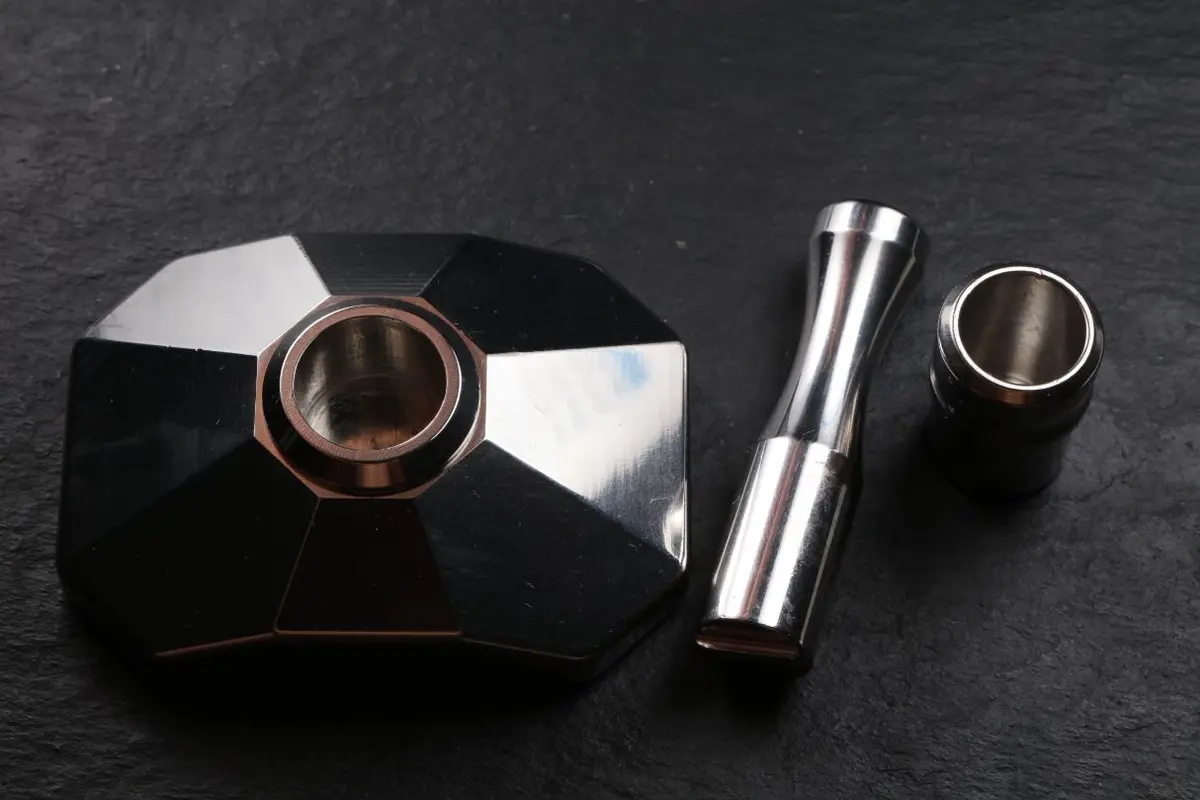 The base seen from above with the cup seated in it, the pestle and a spare cup beside it