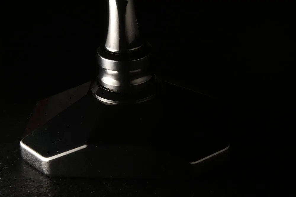 The crusher in profile, almost in silhouette against the black background
