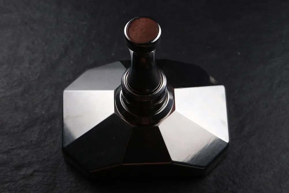 The assembled crusher seen at three quarters, the wooden knob on top of the pestle