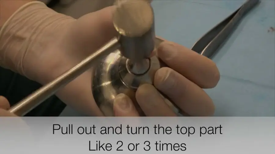 Still from the video: the crusher on the bench, with the pestle in the base